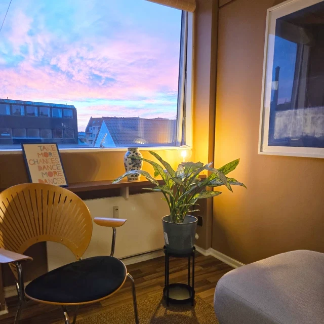 Roligt hjørne i hypnoseklinik i Odense med stol og plante